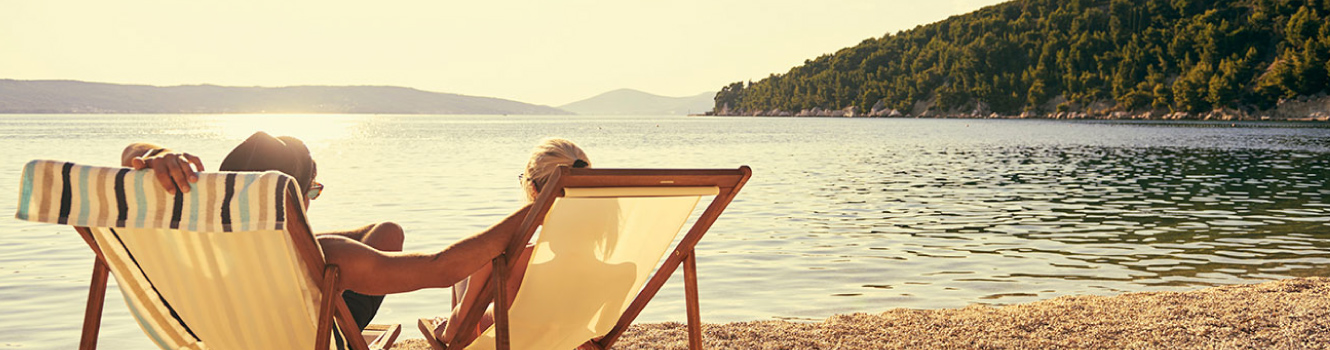 A couple sitting in chairs on the beach